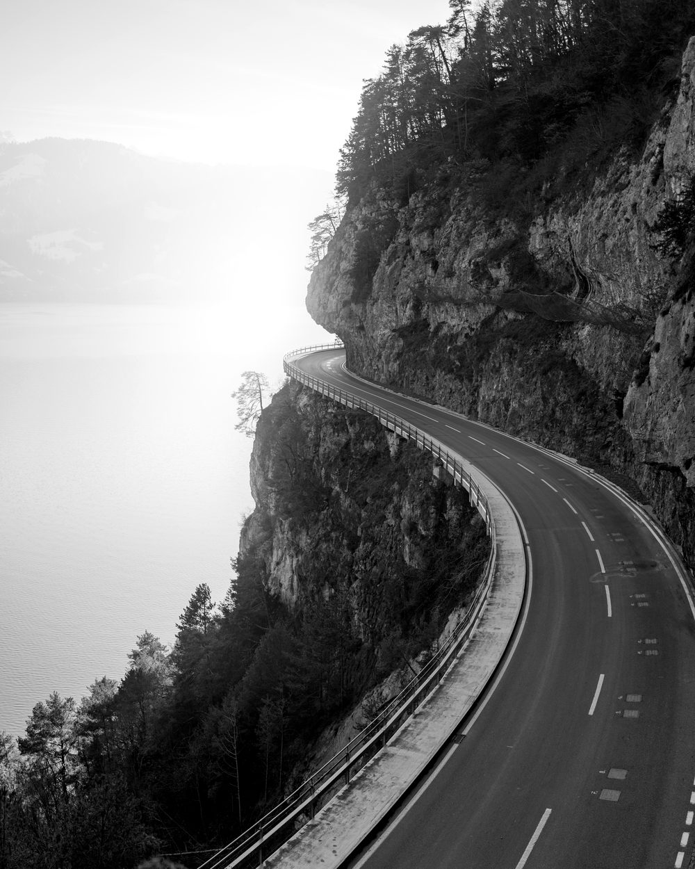 A road curving along a cliff above the sea